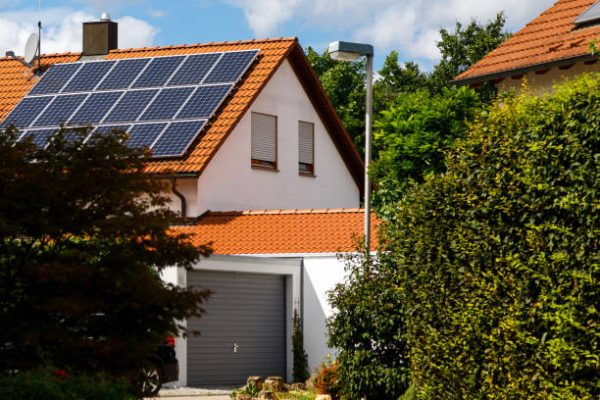 Solar panels on the tiled roof of a building on a bright sunny day. The concept of a good investment, a bargain, an overabundance of energy. Selective focus.