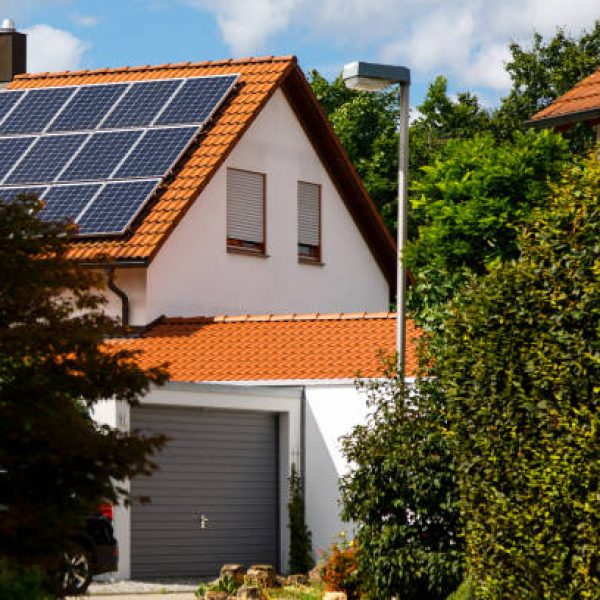 Solar panels on the tiled roof of a building on a bright sunny day. The concept of a good investment, a bargain, an overabundance of energy. Selective focus.